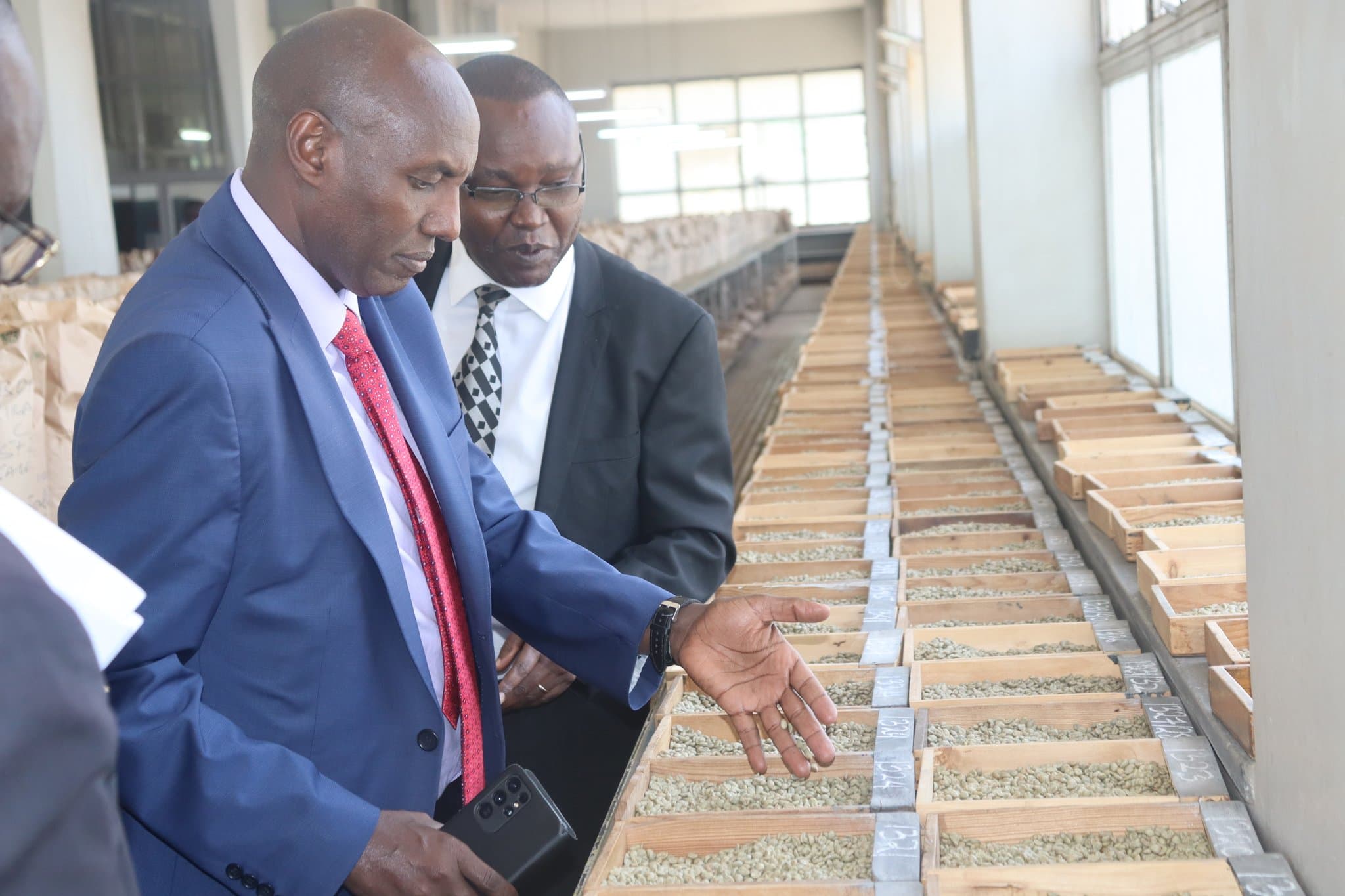 Former Agriculture Principal Secretary Harsama Kello (left) and former NCE chief executive officer Daniel Mbithi at auction sample room. Photo (NCE).